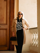 A woman wears jumpsuit-like outfit and a coat